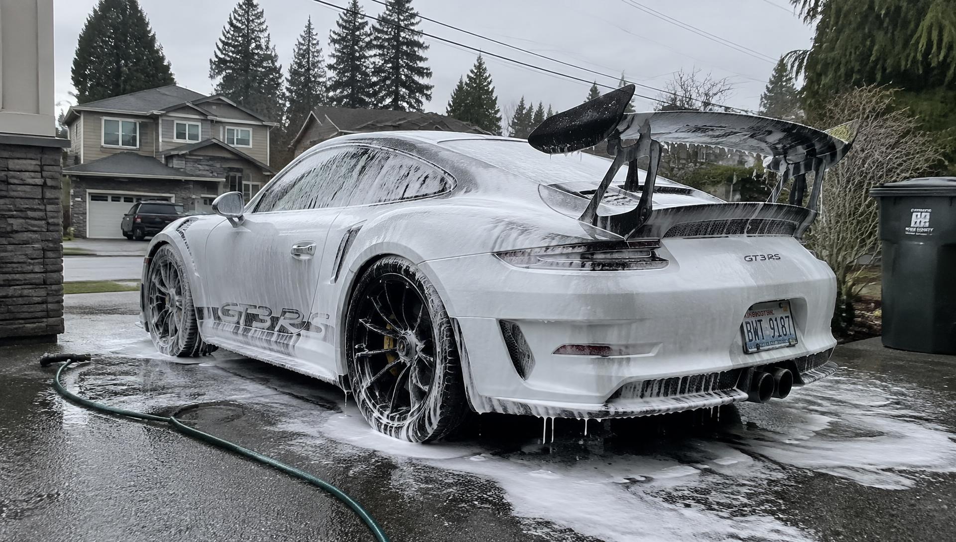 White Porsche 911 GT3 RS covered in snow foam during an exterior detail